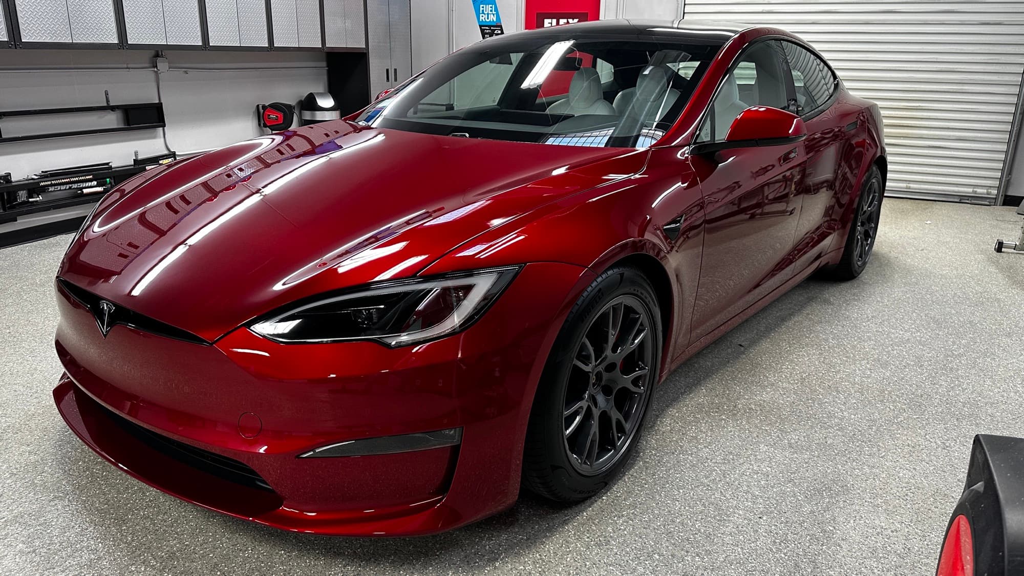 Tesla paint correction work in progress under correction lighting
