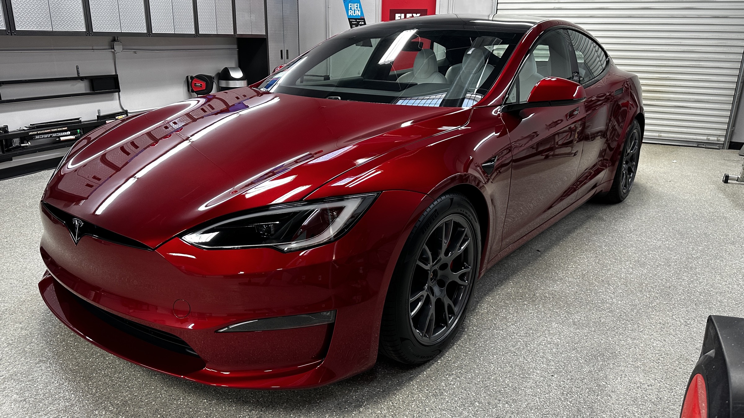Tesla paint correction work in progress under correction lighting